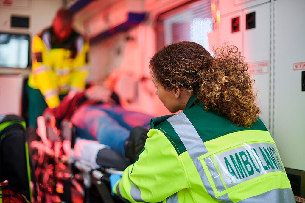 Paramedic unloading a gurney from an ambulance